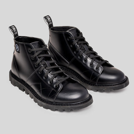 Pair of MNKY high-top black leather boots by FACT. with rectified leather upper, lugged tractor sole, and woven pull tabs.