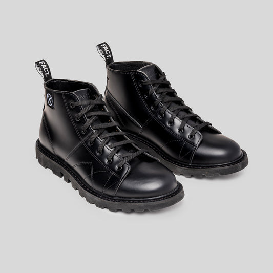 Pair of black leather monkey boots on a light gray background