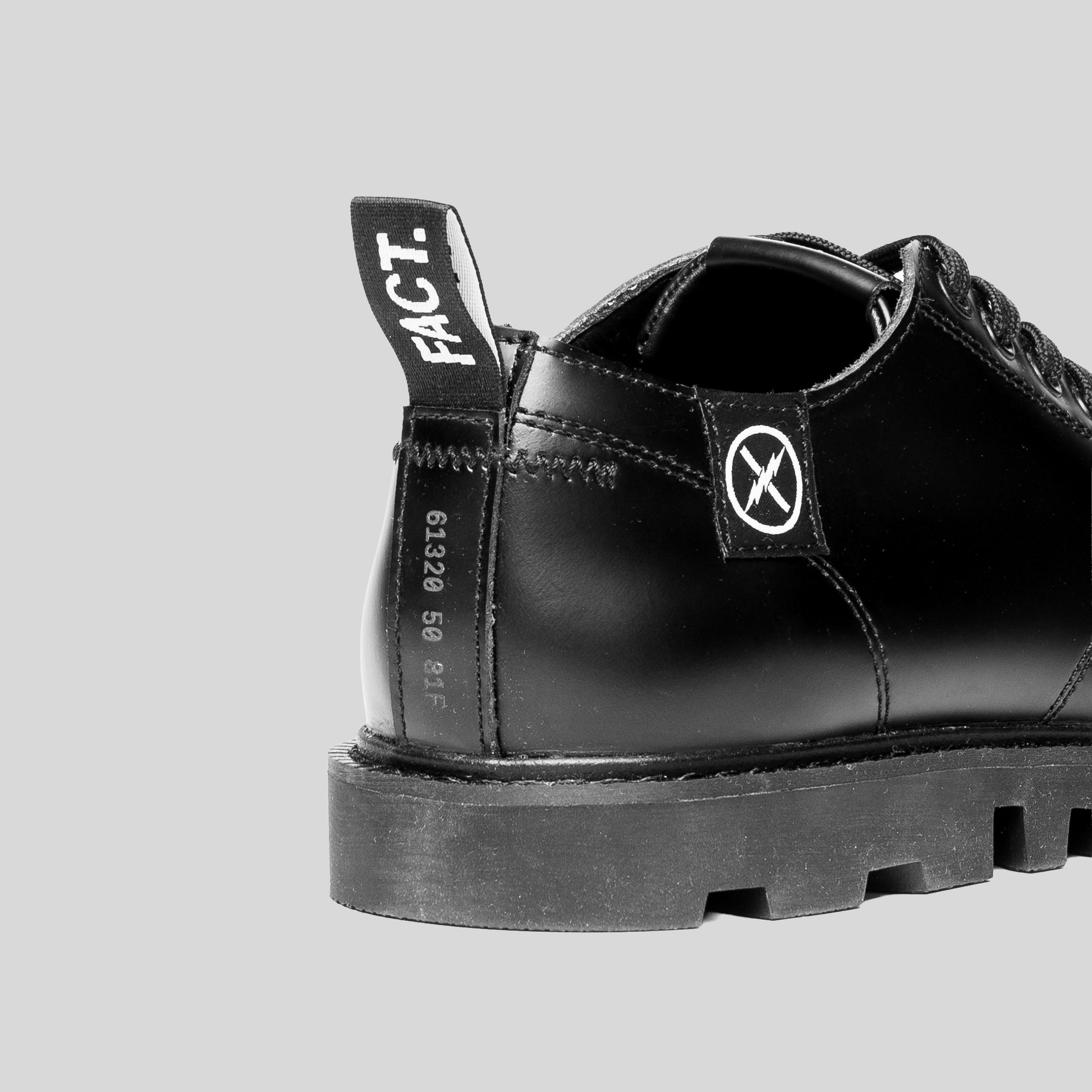 Close-up detail of the FACT. MNKY Shoe heel area, showing stitched construction and FACT. logo patch.