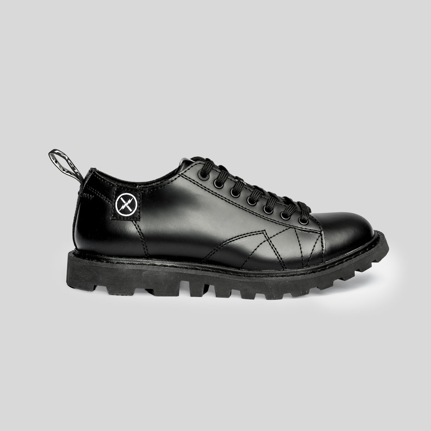 Side view of the FACT. MNKY Shoe showing the low-cut monkey boot profile, lace-up upper, and tractor-style sole.