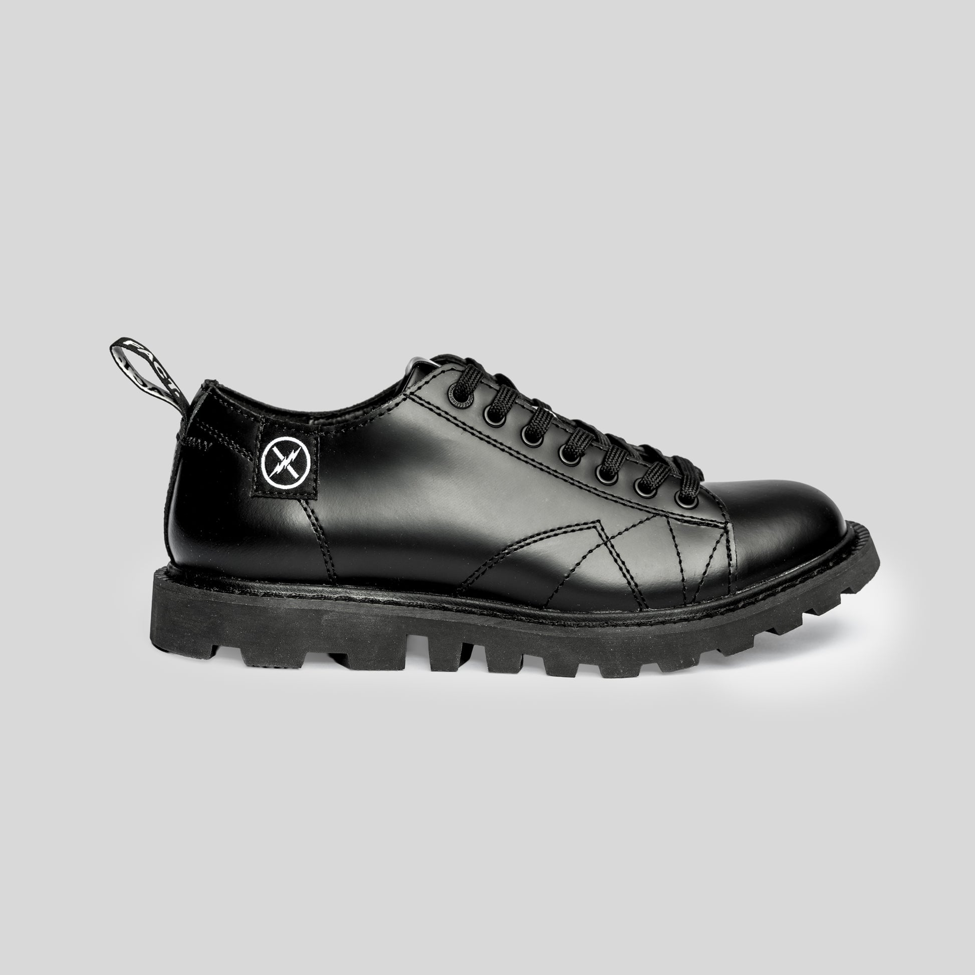 Side view of the FACT. MNKY Shoe showing the low-cut monkey boot profile, lace-up upper, and tractor-style sole.