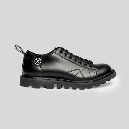 Side view of the FACT. MNKY Shoe showing the low-cut monkey boot profile, lace-up upper, and tractor-style sole.