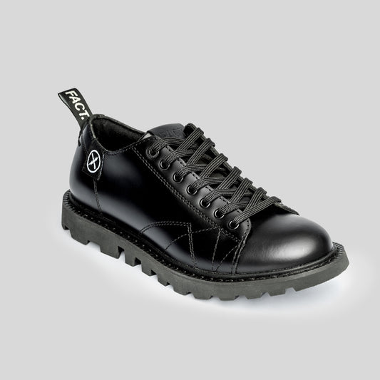 Single FACT. MNKY Shoe in black Italian leather on a studio backdrop, showing the low-cut monkey boot silhouette.